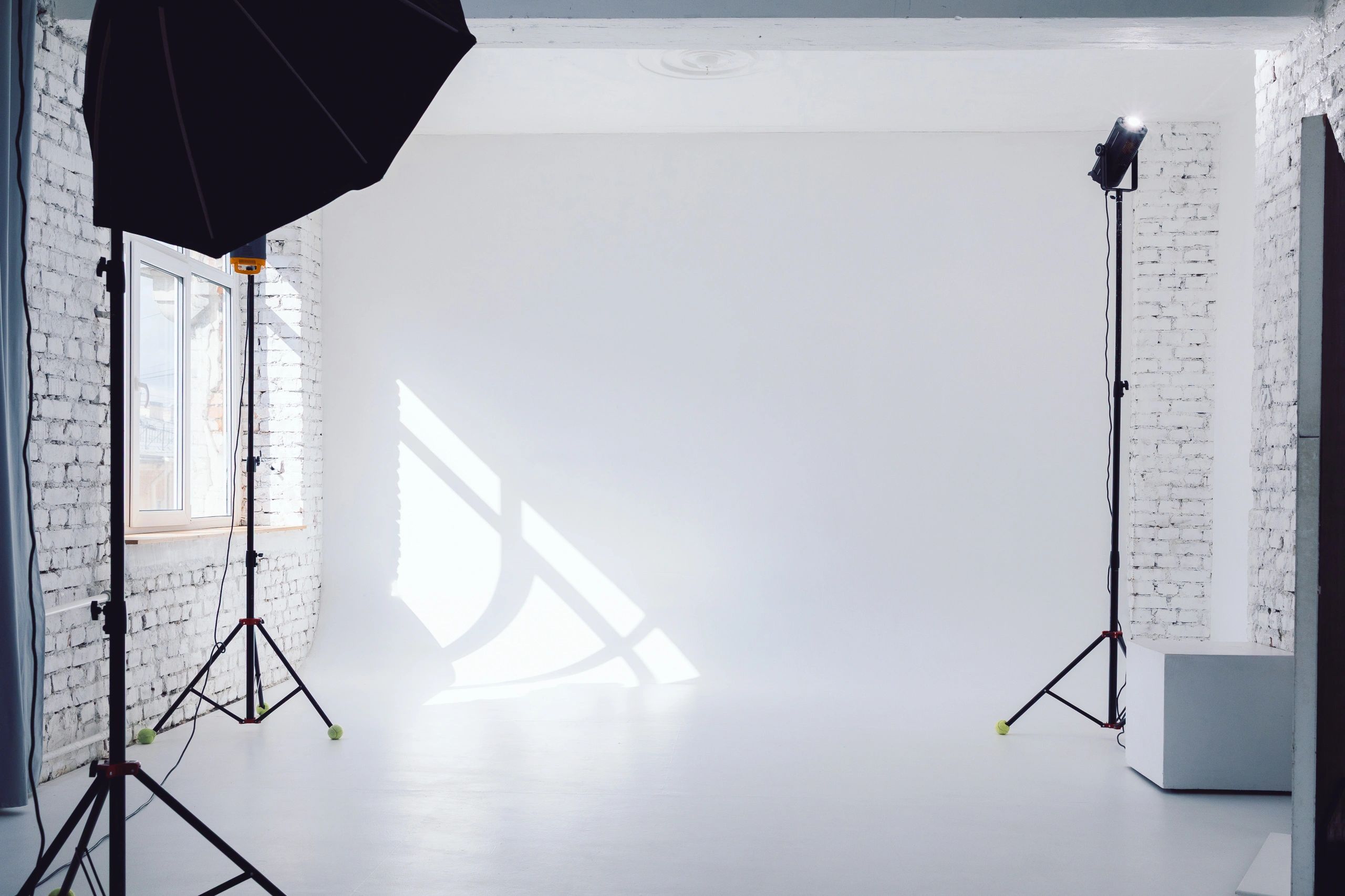 Minimal photo studio with clean white backdrop and professional lighting