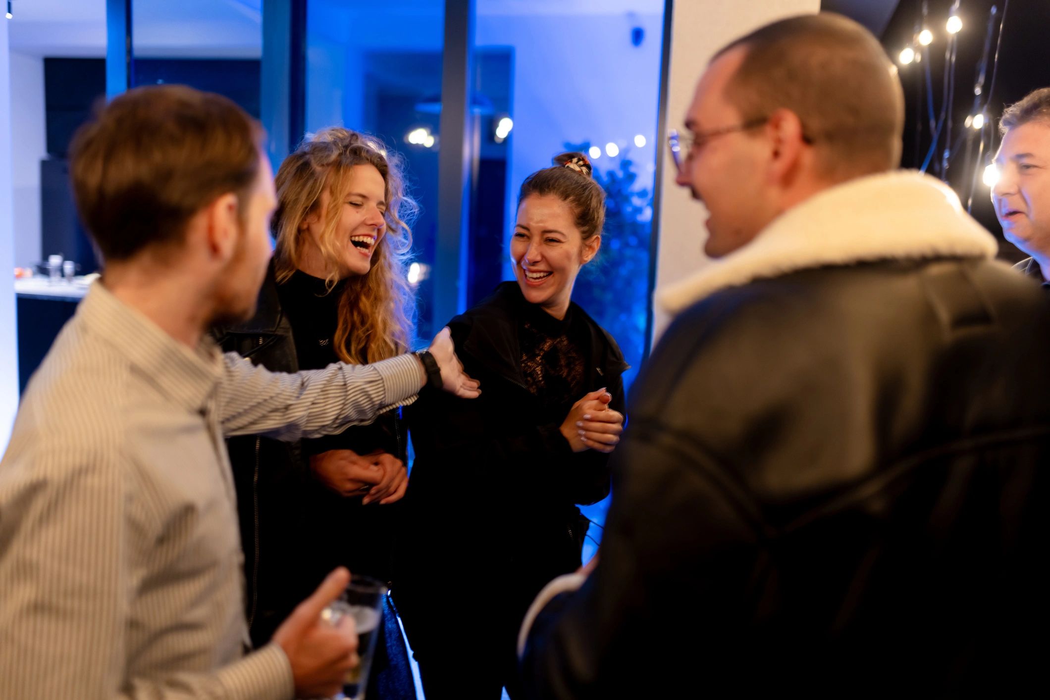Friends laughing together at an indoor social gathering