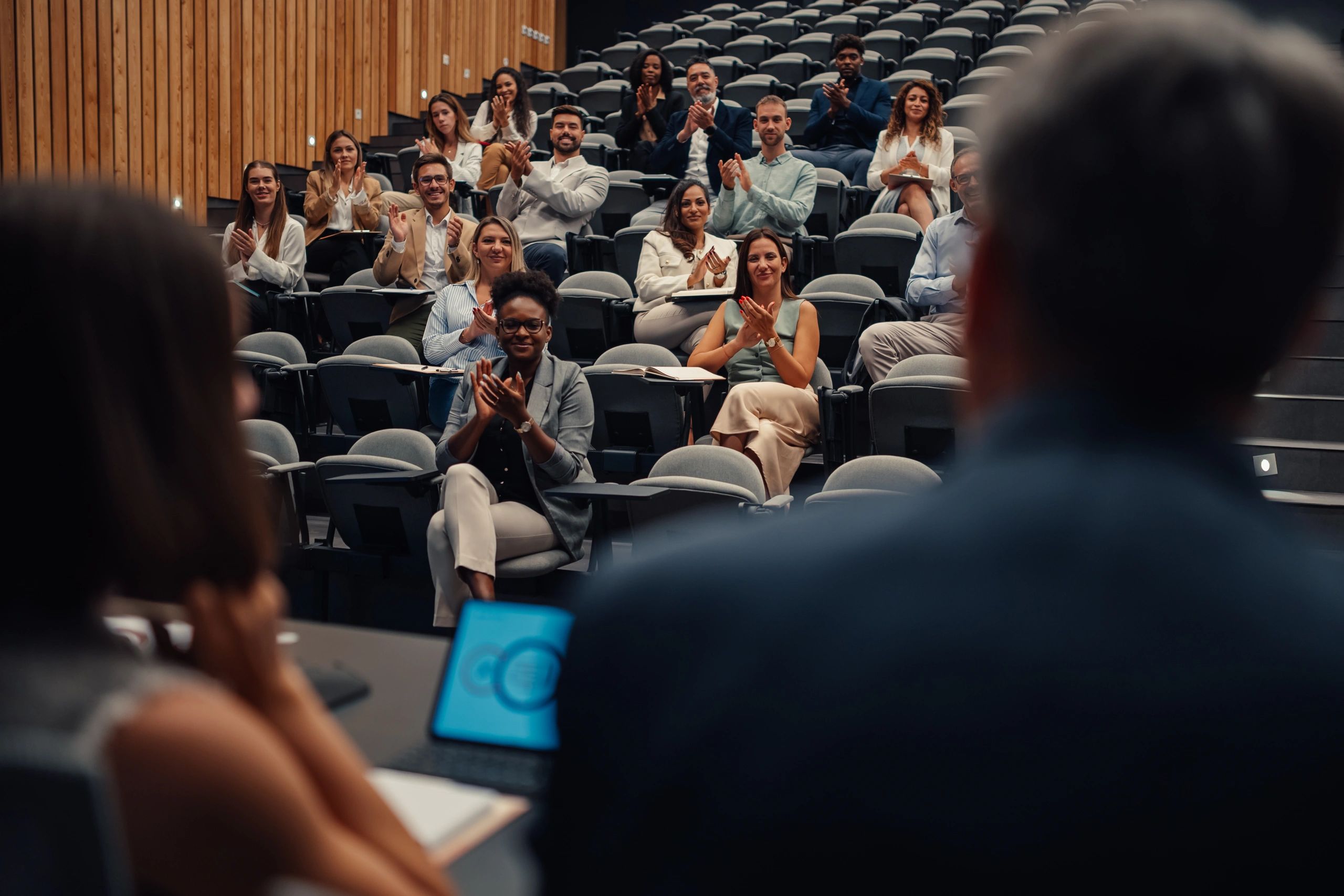 Audience applauding at a conference in a modern venue
