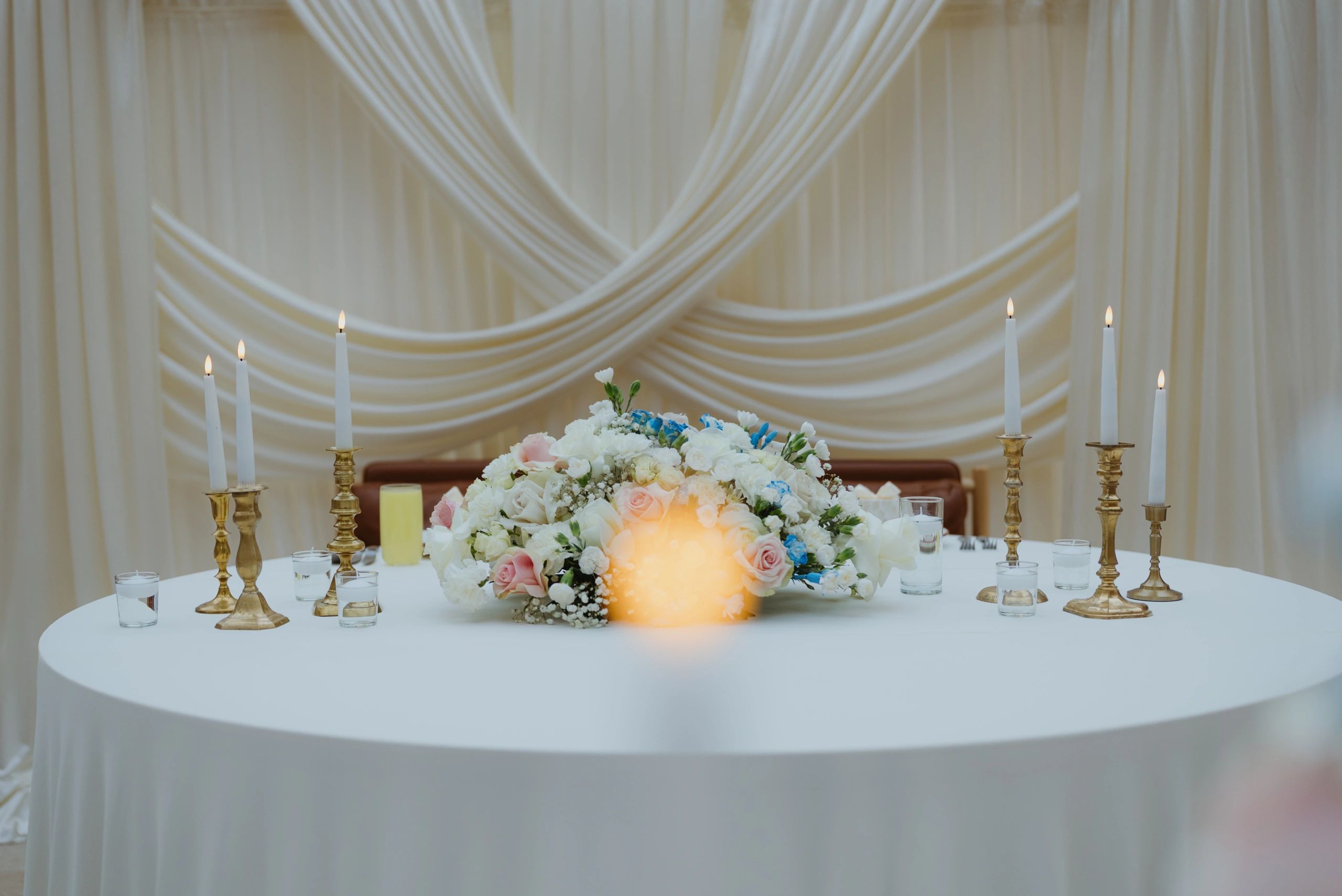 Wedding reception table setting with floral centerpiece and candles